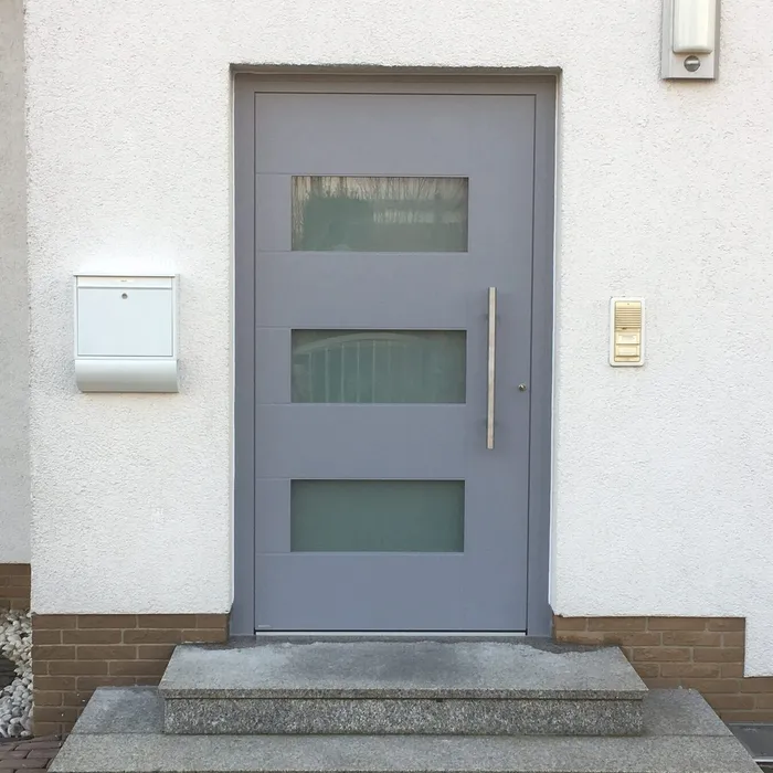 Graue Haustür mit drei senkrechten Lichtausschnitten