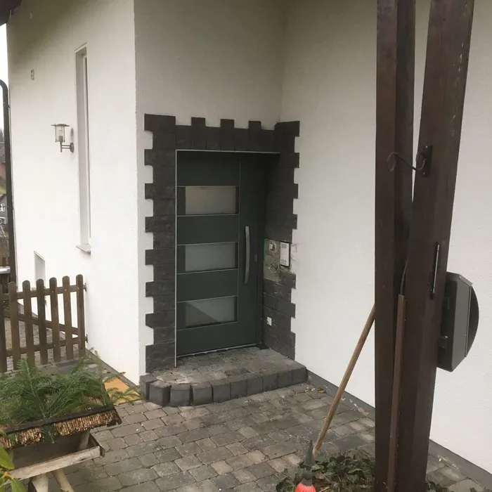 Fenster mit dunklem Rahmen unter einem überdachten Vorbau
