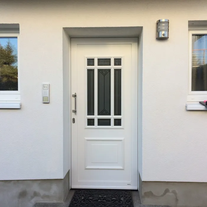 Weiße Haustür im Landhausstil mit Sprossen zwischen zwei Fenstern