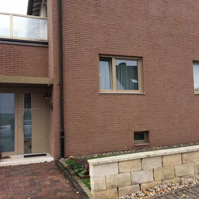 Fenster mit hellen Rahmen in einer roten Klinkerfassade