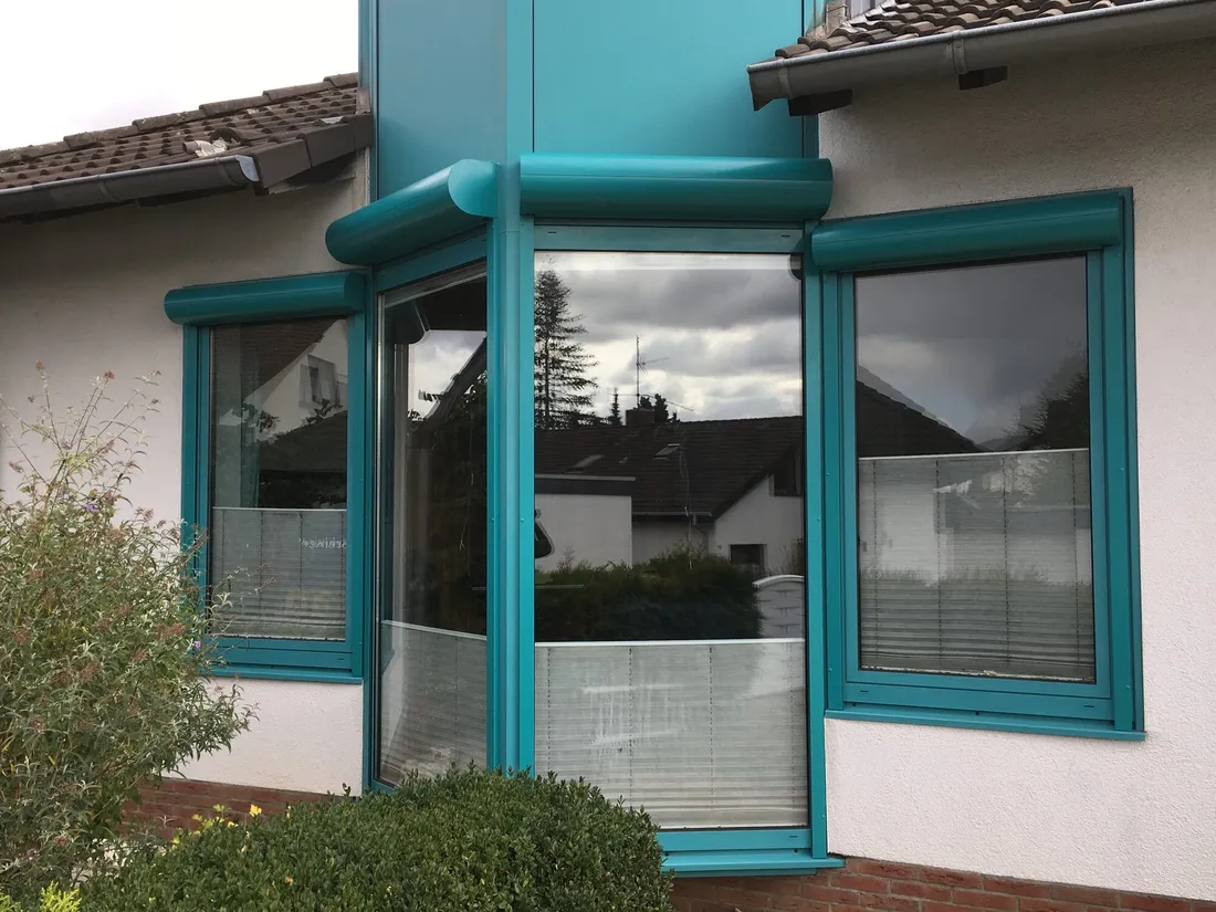 Erker mit vier Vorbaurollläden im RAL-Farbton der Fenster